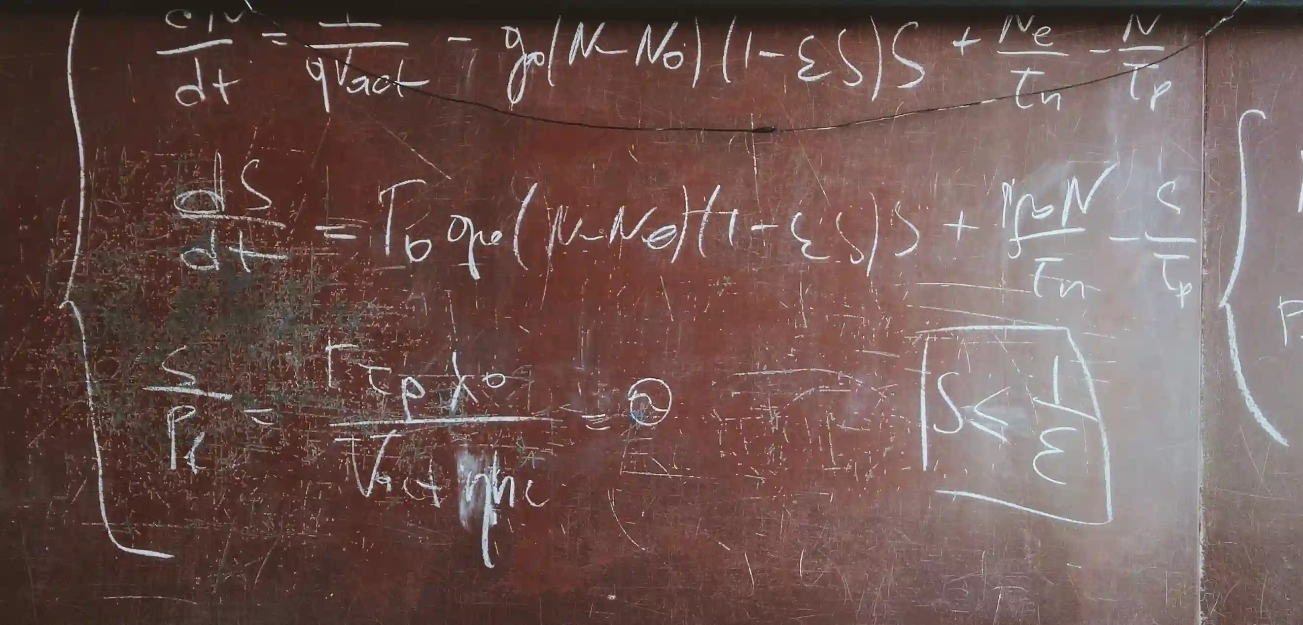 A chalkboard with complex equations written on it